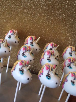 A delicious assortment of Quinceanera-themed dessert owl cake pops, featuring adorable unicorns on top.
