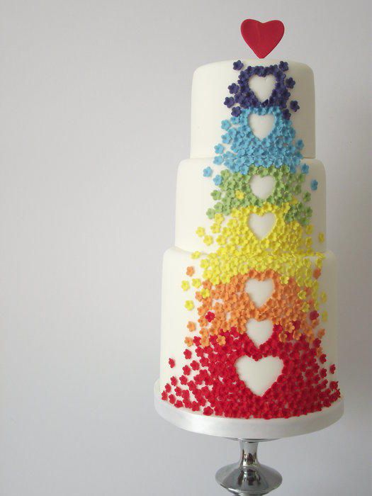 A multicolored Quinceanera cake with hearts on top