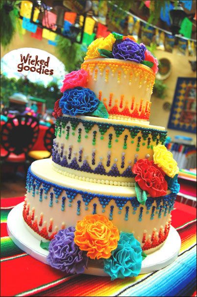 A Mexican crazy themed cake cupcake with multicolored flowers on a table.
