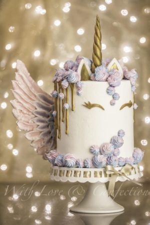 A unique unicorn cake design Cupcake, a white cake with pink and blue icing for a Quinceanera celebration.