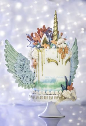 A Quinceanera cake with sugar decorations, featuring a white cake with a unicorn on top