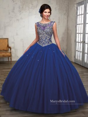 A woman wearing a blue ball gown for a Quinceanera standing in a room
