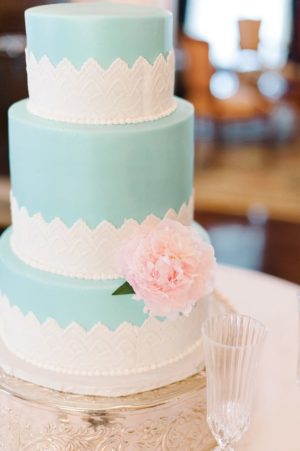 Three tiered Quinceanera cake with a pink flower on top