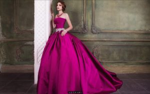 A woman in a pink Quinceañera dress leaning against a wall, showcasing stunning gown Quinceañera dresses