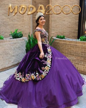 A woman in a purple Quinceañera gown standing in front of a Quinceañera sign