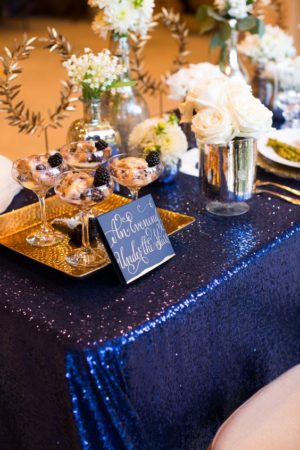 Quinceanera image of a navy blue and gold motif Wedding Invitation on a table topped with a blue table cloth