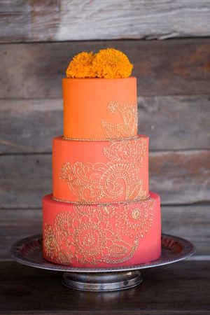 Quinceanera cake, a three tiered cake with orange and gold frosting