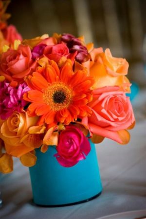 Quinceanera color ideas and invitation, a vase filled with colorful flowers sitting on a table