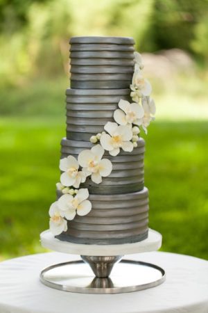 Quinceanera cake, a gray three-tiered cake with white flowers on top