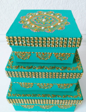 A stack of three Quinceanera-themed boxes with a design on them, one on top of the other. The top box features a beautiful Jasmine design.