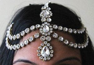 A close up of a woman wearing a jewelry headpiece for a Quinceanera