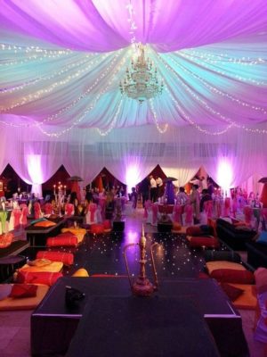 A Quinceanera event with a Moroccan prom theme. The room is filled with lots of tables and chairs.