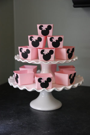 Quinceanera cake, decorated with pink cupcakes on a white cake stand