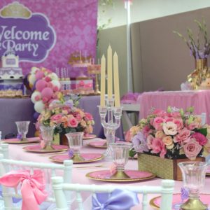 A Quinceanera themed centerpiece with a floral design, set on a table for a baby shower party