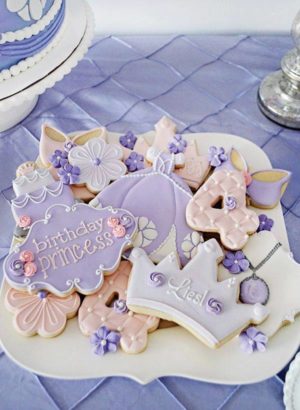A plate of decorated Quinceanera cookies featuring a princess Sofia theme