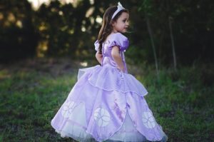 Quinceanera: A little girl in a lavender gown, standing in a field like a princess.