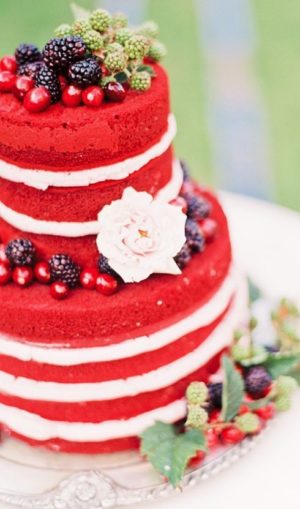 A three layer Quinceanera cake with whipped cream and berries on top
