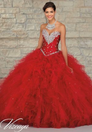 Quinceañera dresses, a woman in a red dress standing in front of a brick wall with diamonds