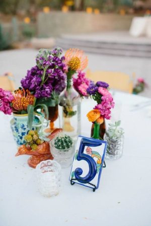 A table topped with vases filled with flowers and a flower bouquet with a floral design