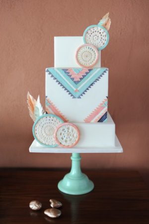 A Quinceanera themed cupcake with tribal cake designs. The three-tiered cake is decorated with feathers.