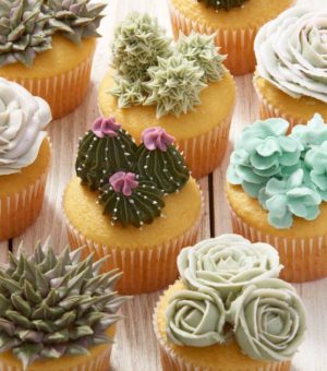 A bunch of Quinceanera cupcakes decorated with different types of flowers using the Wilton Starter Decorating Tip Set.