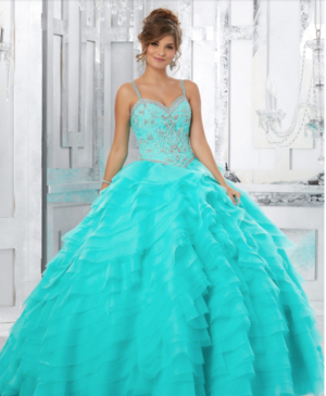 A woman in a blue dress posing for a picture wearing Quinceañera dresses