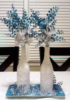 Quinceanera-themed image with wine bottles, Christmas crafts, and a couple of vases sitting on a table