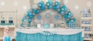 A Quinceañera themed table with balloons and decorations, resembling a frozen birthday party