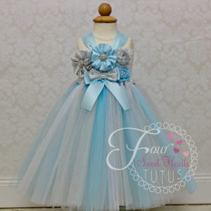 A Quinceanera dress of a little girl wearing a blue dress with flowers on it
