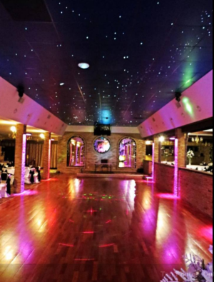A Quinceanera banquet hall, featuring a large room with a lot of lights on the ceiling
