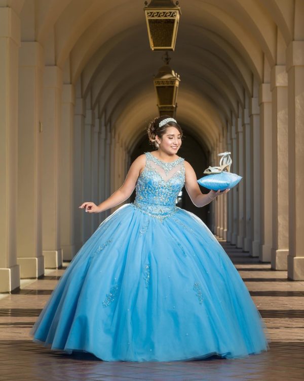 A woman in a blue Quinceañera gown holding a bowl.