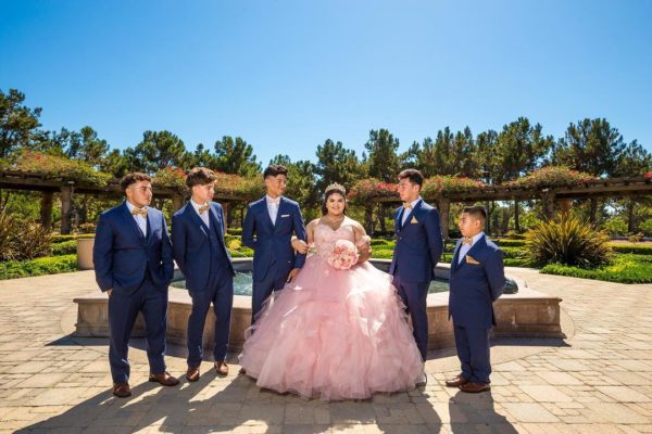 A Quinceanera celebration in Bill Barber Memorial Park. A quinceañera and her court of honor pose for a group photo.