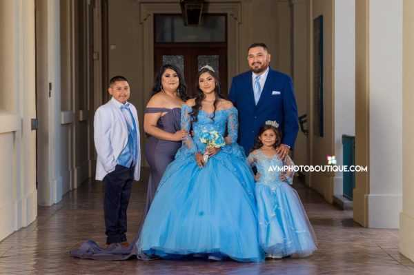 Quinceanera gown, a family posing for a picture in a hallway
