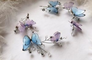 A close up of a lilac bracelet adorned with flowers and butterflies for a Quinceanera celebration.
