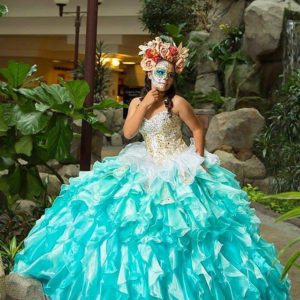 Quinceanera gown, a woman in a blue and white dress posing for a picture