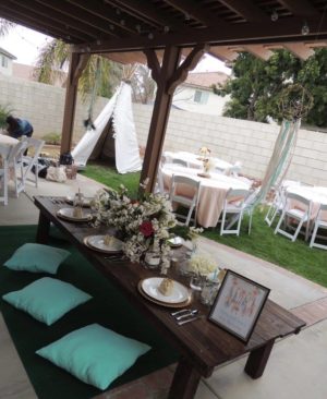 Table set up for a Quinceanera party with a teepee tent in the background