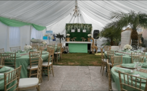 A Quinceañera ceremony with a tent set up for a party, with tables and chairs