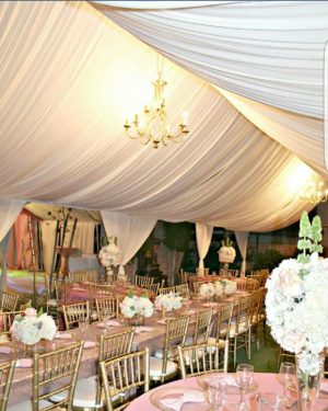 Floral design, a Quinceanera reception is set up in a function hall and tent
