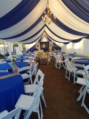 A Quinceanera celebration in a function hall party, with a large tent set up with tables and chairs