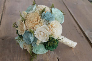 A beautiful floral design, a bouquet of flowers sitting on top of a wooden table