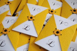 A bunch of yellow and white cards with sunflowers on art paper