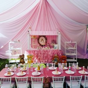 A Quinceanera celebration in a function hall with a table set up for a girl's birthday party