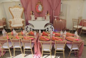 A dining room table set up for a Quinceanera, featuring a princess themed party