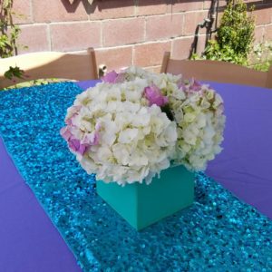 A beautiful Quinceanera floral design featuring a flower bouquet and a table with a vase of flowers on it