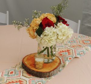 Quinceanera decoration with cut flowers and a vase of flowers on a table