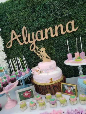 A table topped with lots of cupcakes and cakes for a Quinceanera cake decorating event