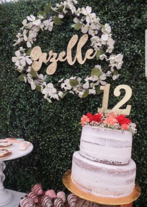 Quinceanera image: a table topped with a boho-themed 13th birthday cake covered in frosting