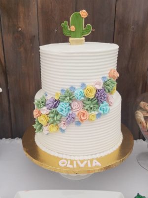 Quinceanera cake with buttercream and flowers, featuring a cactus on top