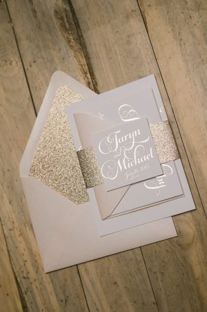 Quinceanera invitation, a white and gold Quinceanera invitation on a wooden table