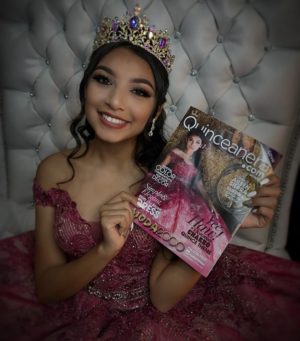A beautiful woman in a pink Quinceanera dress holding a Quinceanera magazine, showcasing a stunning Quinceanera hairstyle.